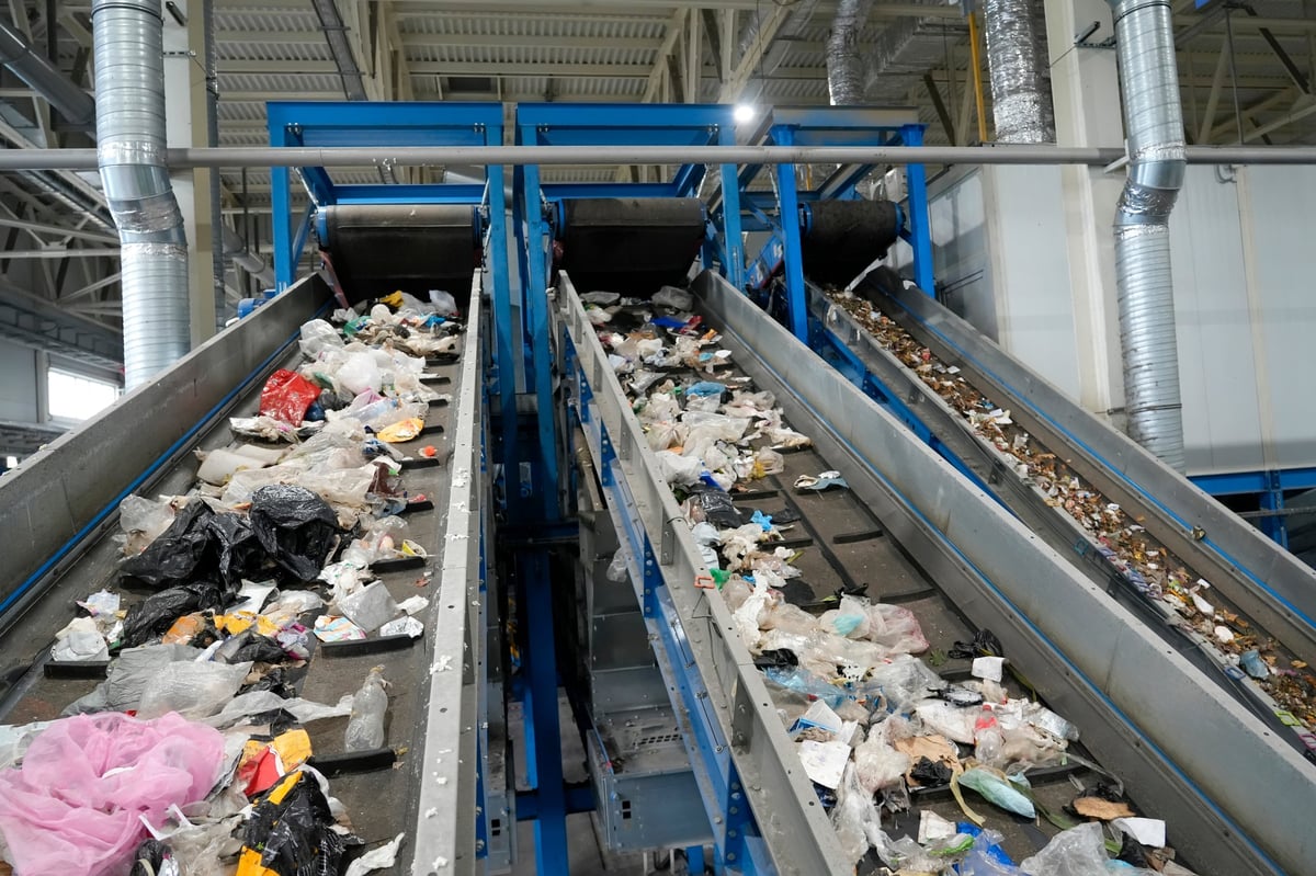 Industrial conveyor belts carrying waste materials inside a recycling facility for sorting